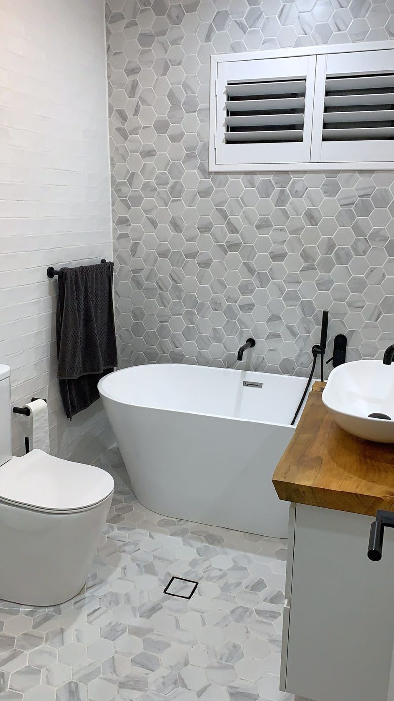 A freestanding tub and mounted TV feature in this finished bathroom.