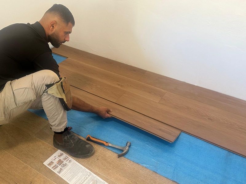 Laying new timber flooring during a renovation.
