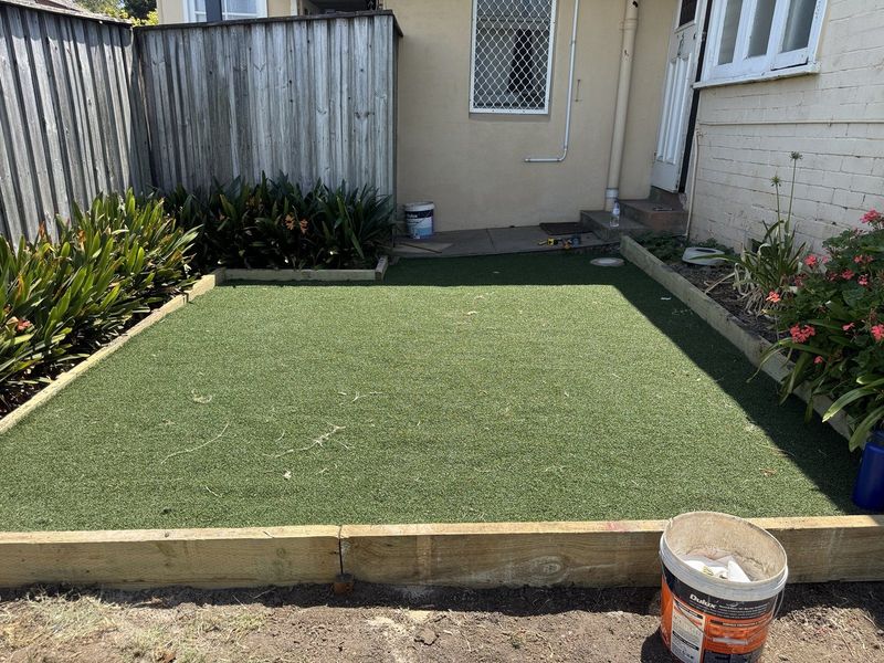 Laid synthetic turf squared off inside new timber edging
