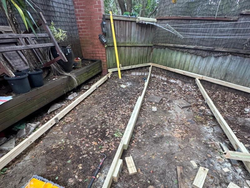 New treated pine bearers being set out and levelled beside the brick wall