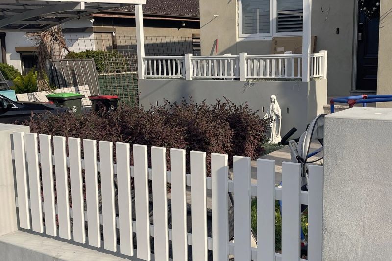 White picket fence and gate in a rendered Sydney front yard