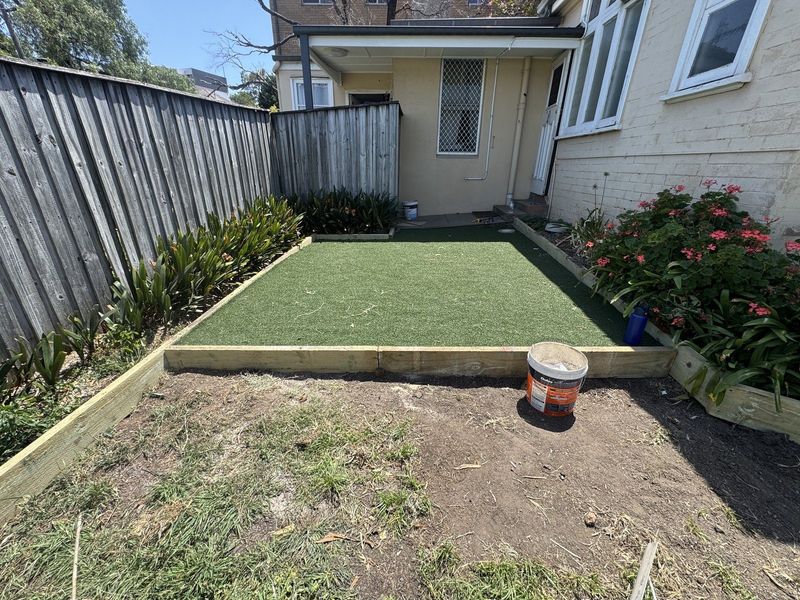 Bare dirt yard with old edging removed, ready for new turf