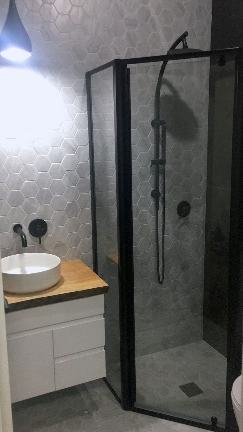 Black tile walls and a freestanding tub finish this Sydney bathroom renovation.
