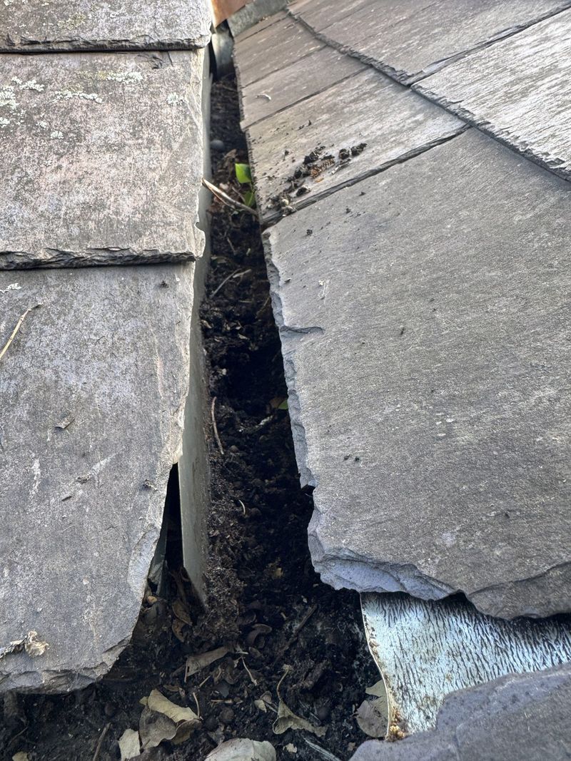 Close-up of a cracked roof tile repaired with sealant
