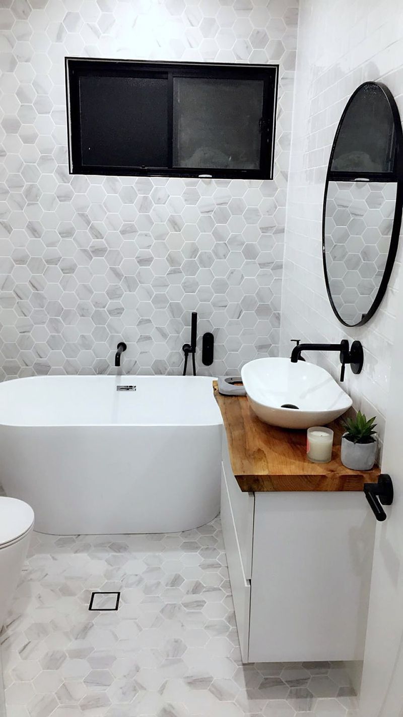 Freestanding bathtub beside a hexagon-tiled floor in this Sydney bathroom.
