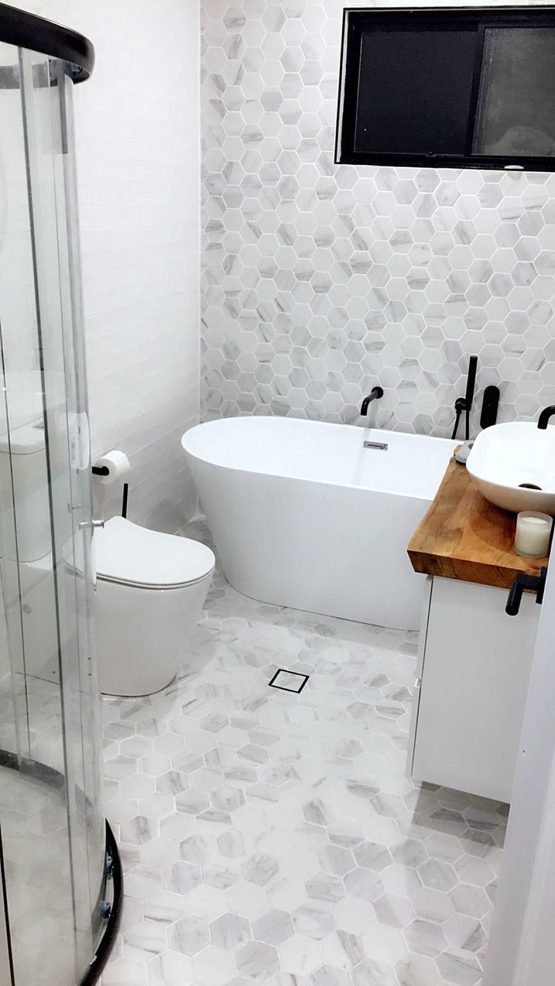 A pendant light hangs above the vessel sink in this finished bathroom.