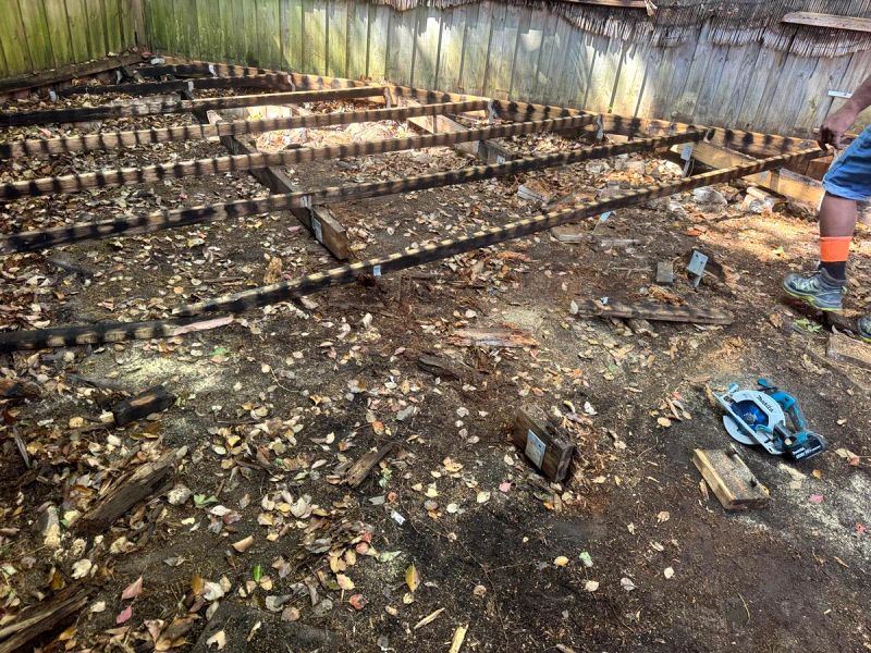Old deck boards lifted to expose the original bearers and joists