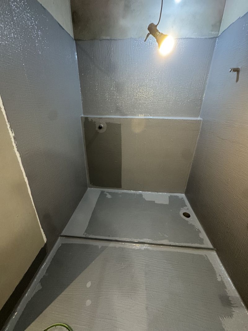 Membrane over the shower floor with falls graded to the waste outlet