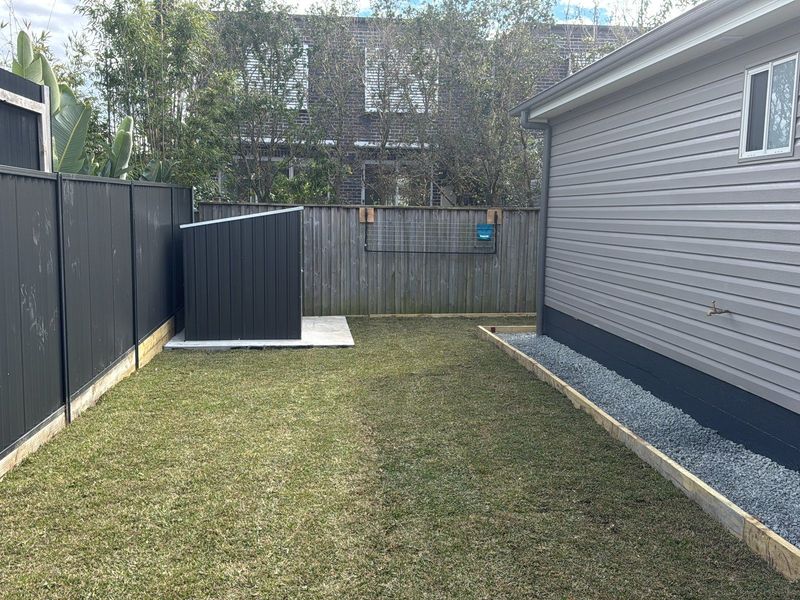 Granny flat exterior alongside a new Colorbond boundary fence