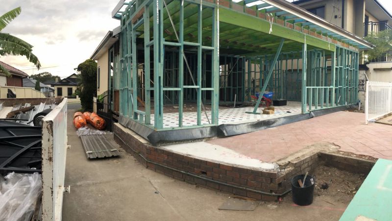 Steel wall framing erected along the rear of a house for a new extension