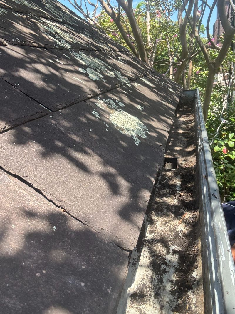 Same gutter run, bare metal and cleared, after the repair
