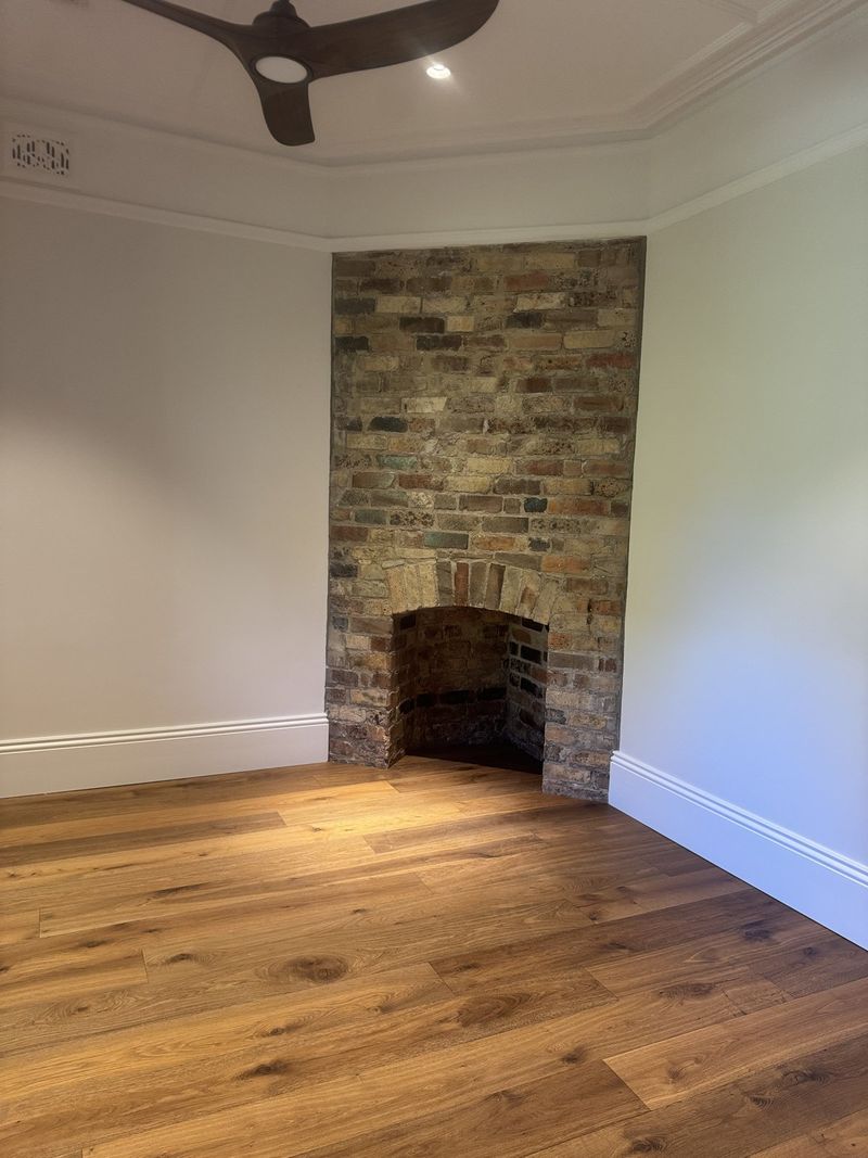 Restored brick fireplace in a finished room with new timber flooring