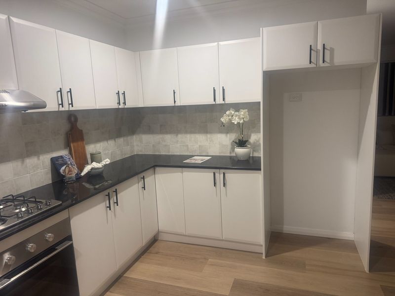 Corner kitchen cabinetry finished with a stone benchtop and gas cooktop.