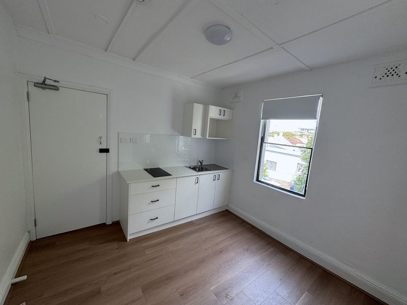 Finished kitchenette room with cabinets and floorboards