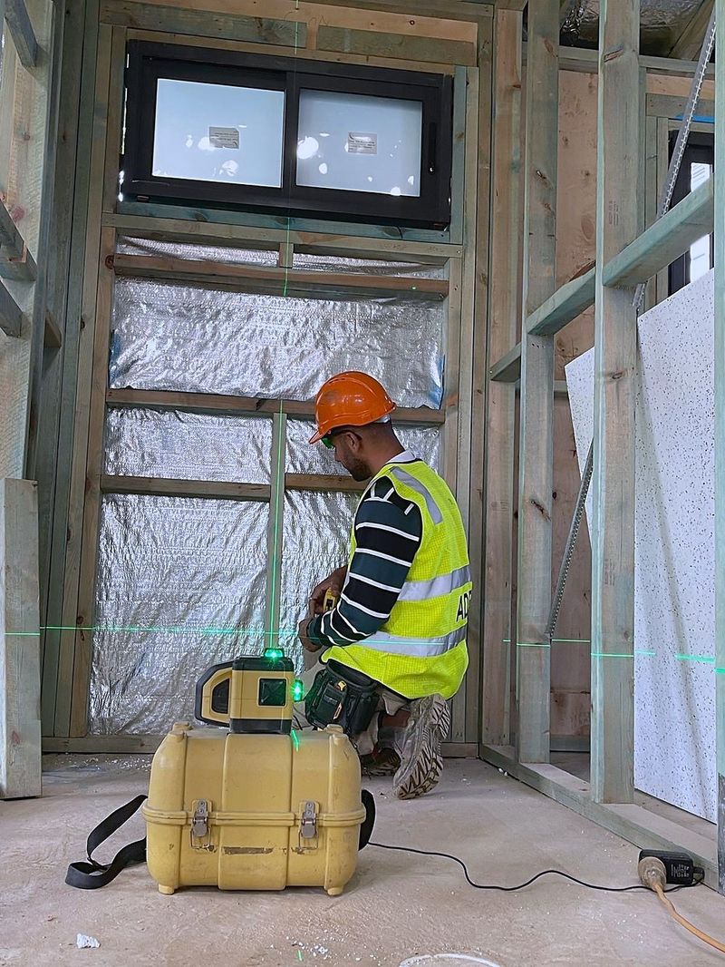 Tradesperson setting out a framed room with a laser level