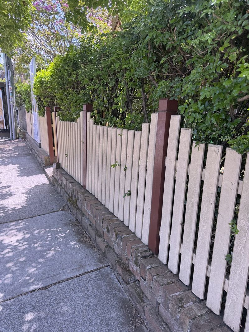 White picket fence running along a footpath in a Sydney street