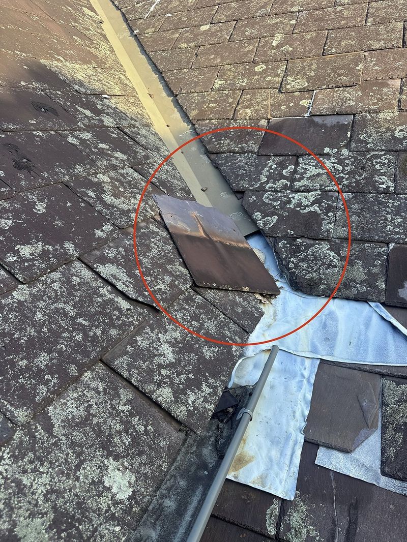 Slipped slate and exposed flashing identified during a roof inspection